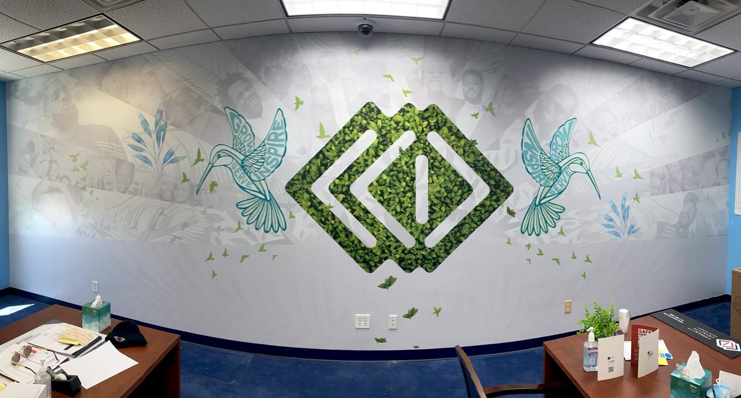 Community office feature wall with leaf logo and hummingbirds