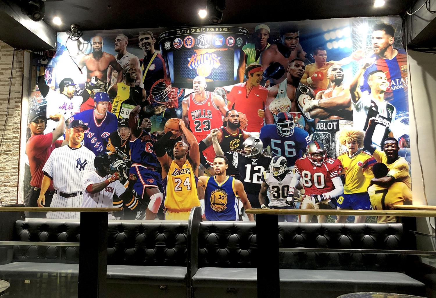 Sports legends wall mural above booth seating at Nutty Sports Bar & Grill