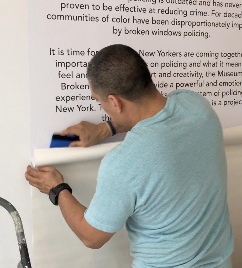 Installer smoothing a printed text wall panel